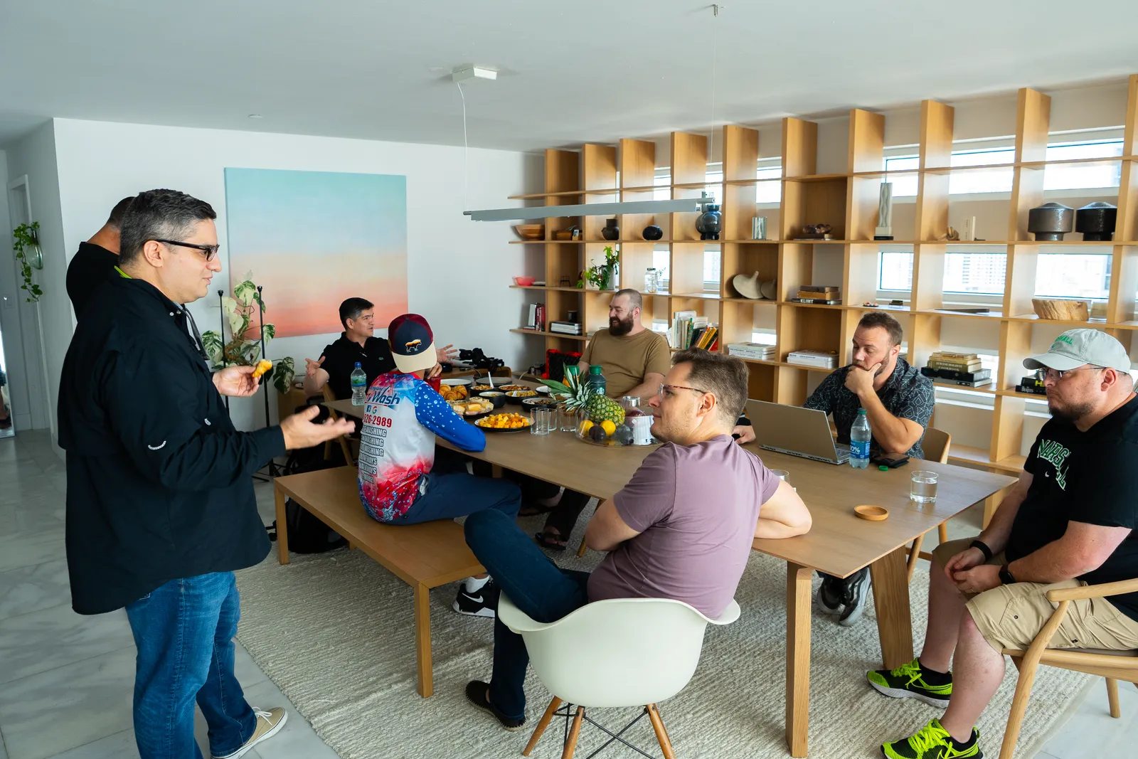 Agency owners in a roundtable discussion around a long table, Geoff seated at right with a laptop