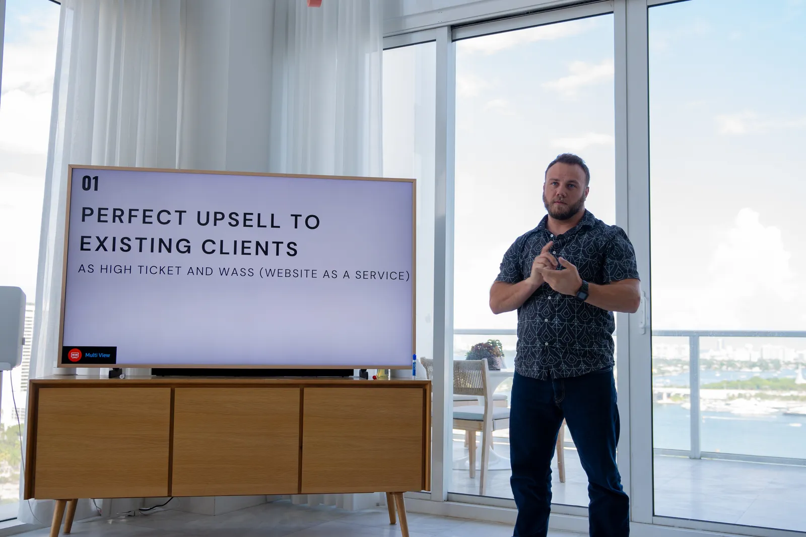 Geoff Bybee presenting a slide titled Perfect upsell to existing clients to a room of agency owners